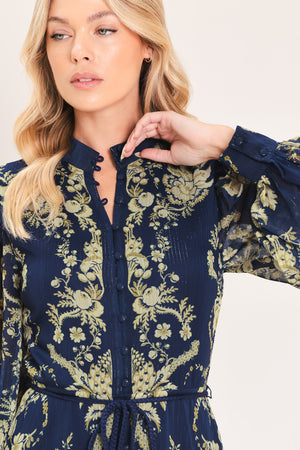 A woman modeling a long-sleeved navy blue maxi dress with a taupe toile floral pattern | Flying Tomato