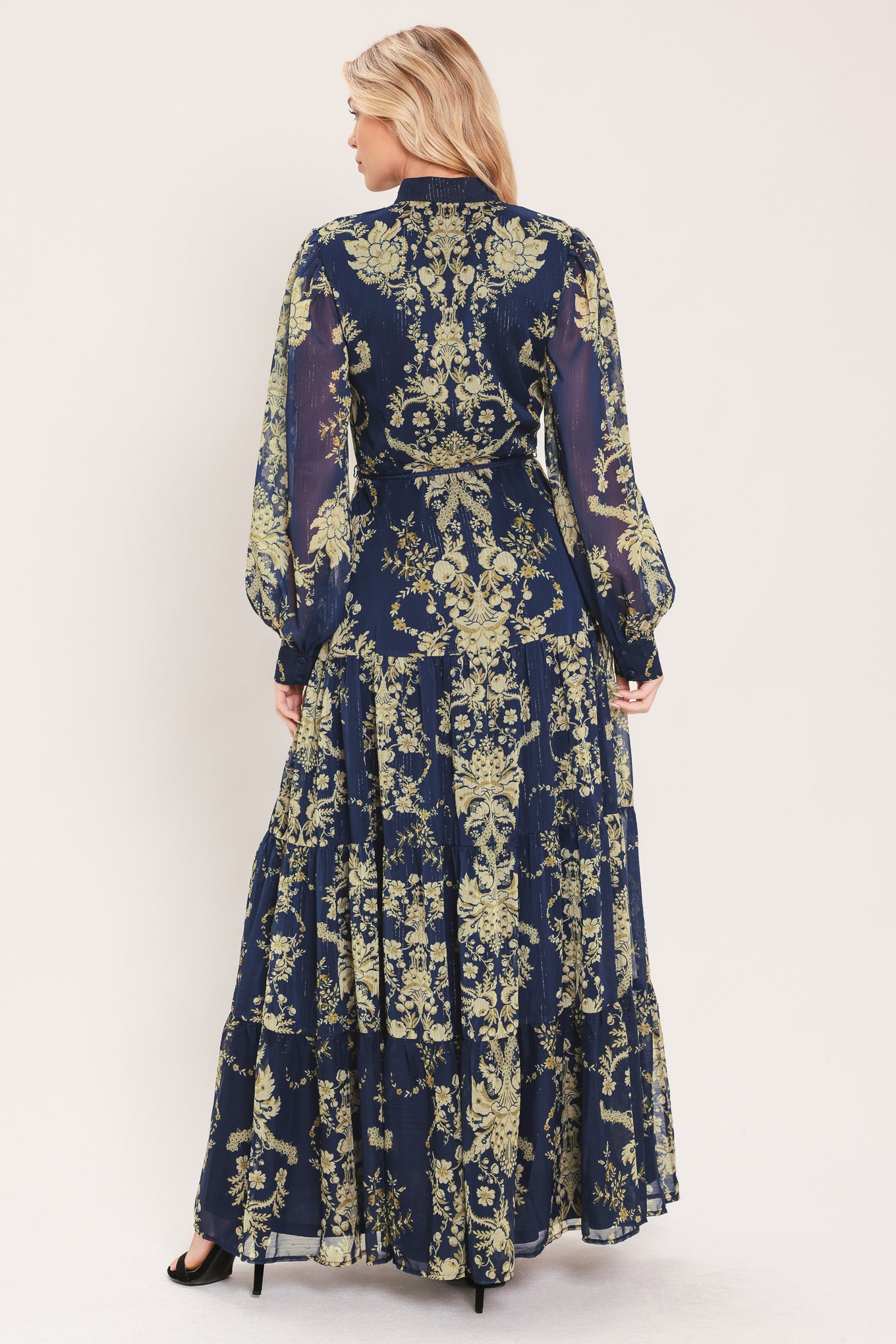 A woman modeling a long-sleeved navy blue maxi dress with a taupe toile floral pattern | Flying Tomato