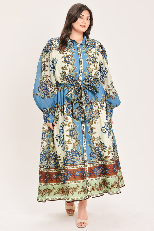 A woman wearing a long-sleeved midi dress with a blue, beige, and brown floral pattern, featuring a tie waist belt | Flying Tomato Curve