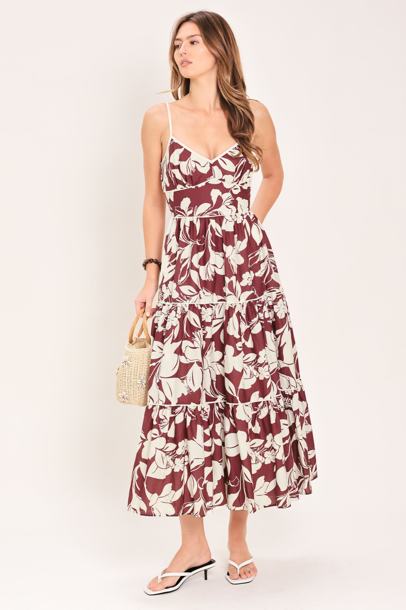 Woman wearing a floral maroon midi dress featuring cami top, waist yoke, tier skirt and smocked back bodice | Flying Tomato
