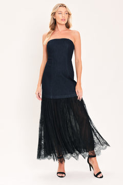 A woman modeling a strapless dark blue maxi dress with a fitted denim-like bodice and a flowing sheer tulle skirt with lace trim | Flying Tomato