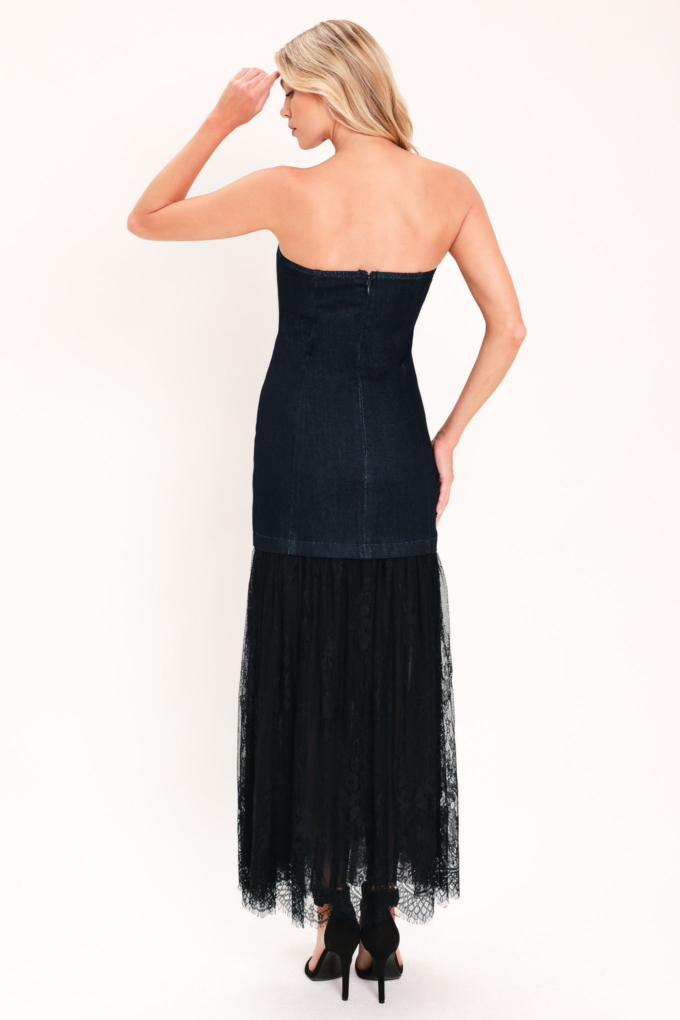A woman modeling a strapless dark blue maxi dress with a fitted denim-like bodice and a flowing sheer tulle skirt with lace trim | Flying Tomato