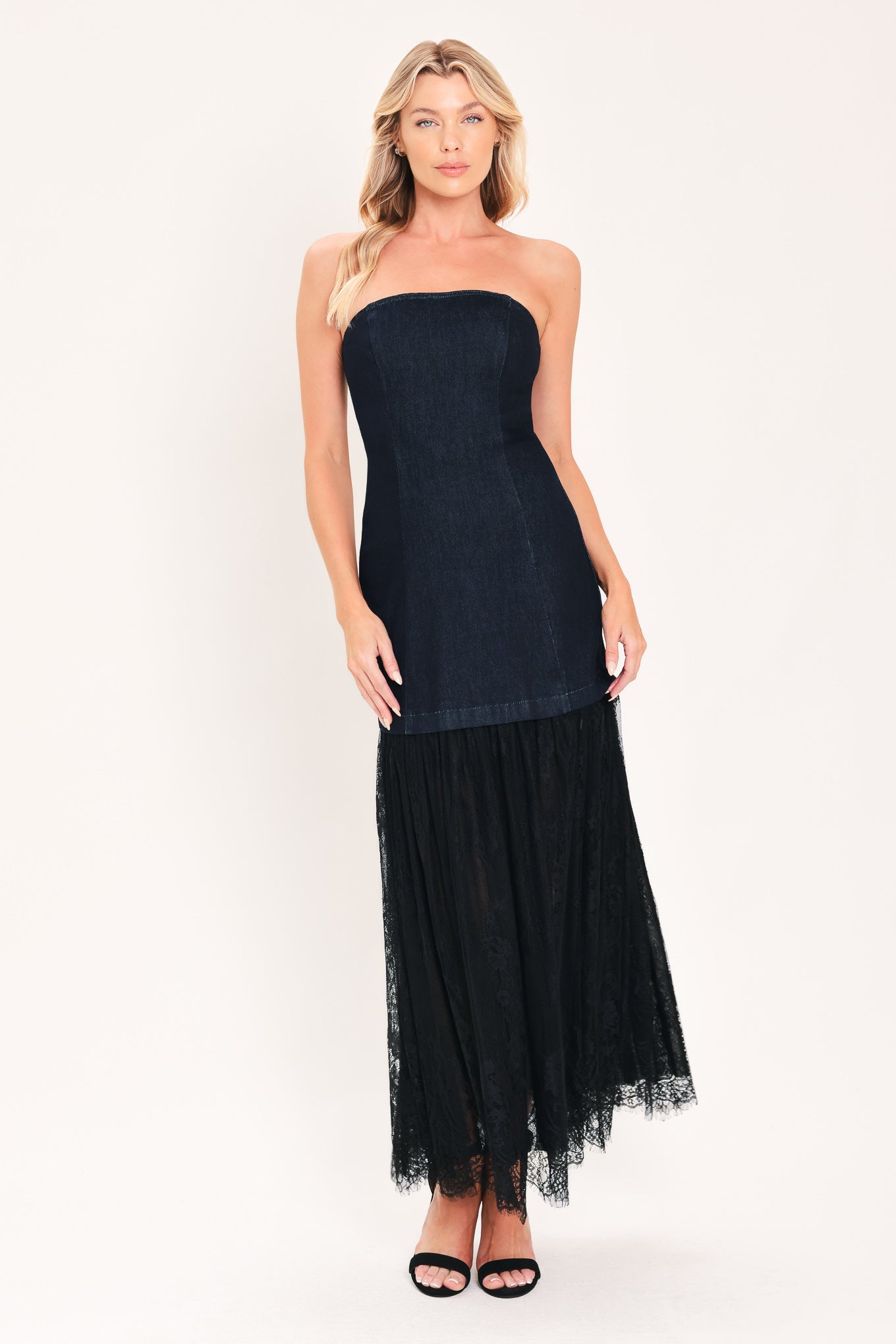 A woman modeling a strapless dark blue maxi dress with a fitted denim-like bodice and a flowing sheer tulle skirt with lace trim | Flying Tomato