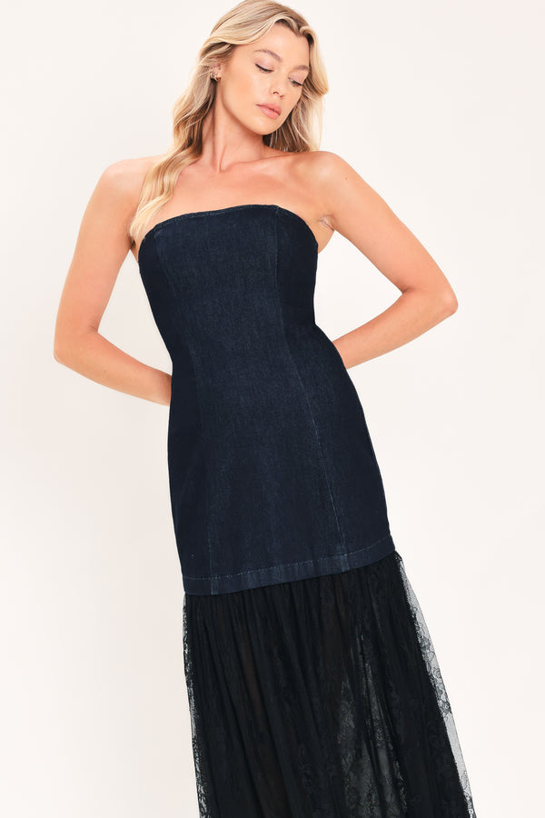 A woman modeling a strapless dark blue maxi dress with a fitted denim-like bodice and a flowing sheer tulle skirt with lace trim | Flying Tomato