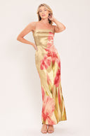 A woman modeling a maxi satin slip dress with a champagne gold base and a large pink floral print | Flying Tomato