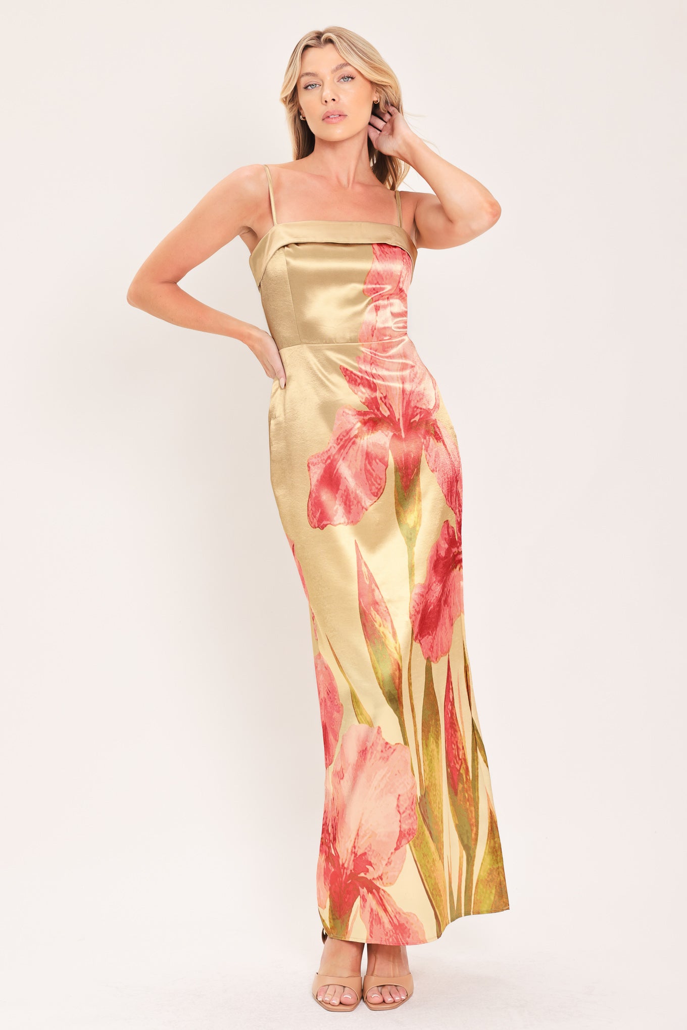 A woman modeling a maxi satin slip dress with a champagne gold base and a large pink floral print | Flying Tomato