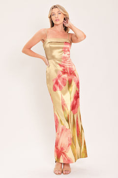 A woman modeling a maxi satin slip dress with a champagne gold base and a large pink floral print | Flying Tomato