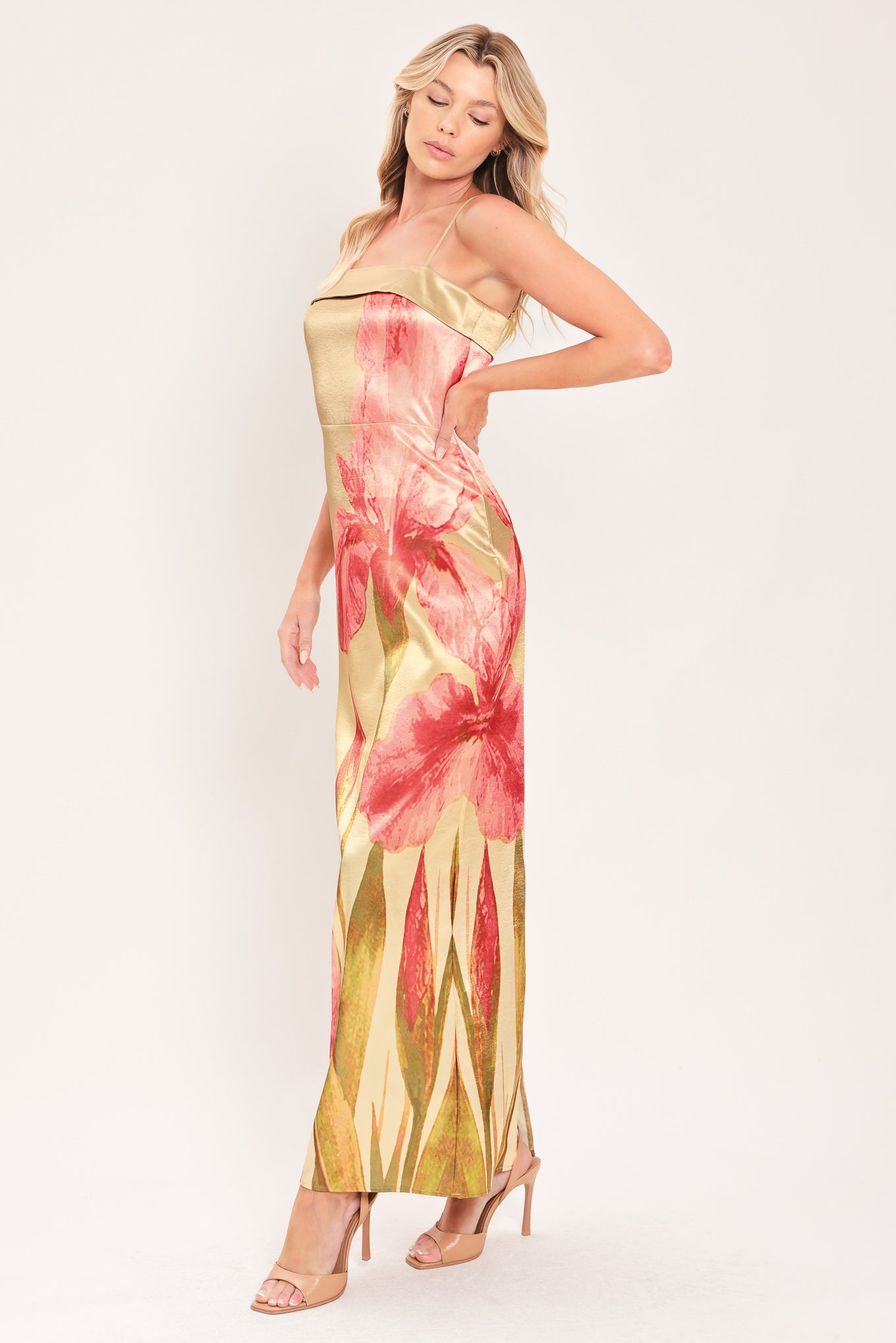 A woman modeling a maxi satin slip dress with a champagne gold base and a large pink floral print | Flying Tomato