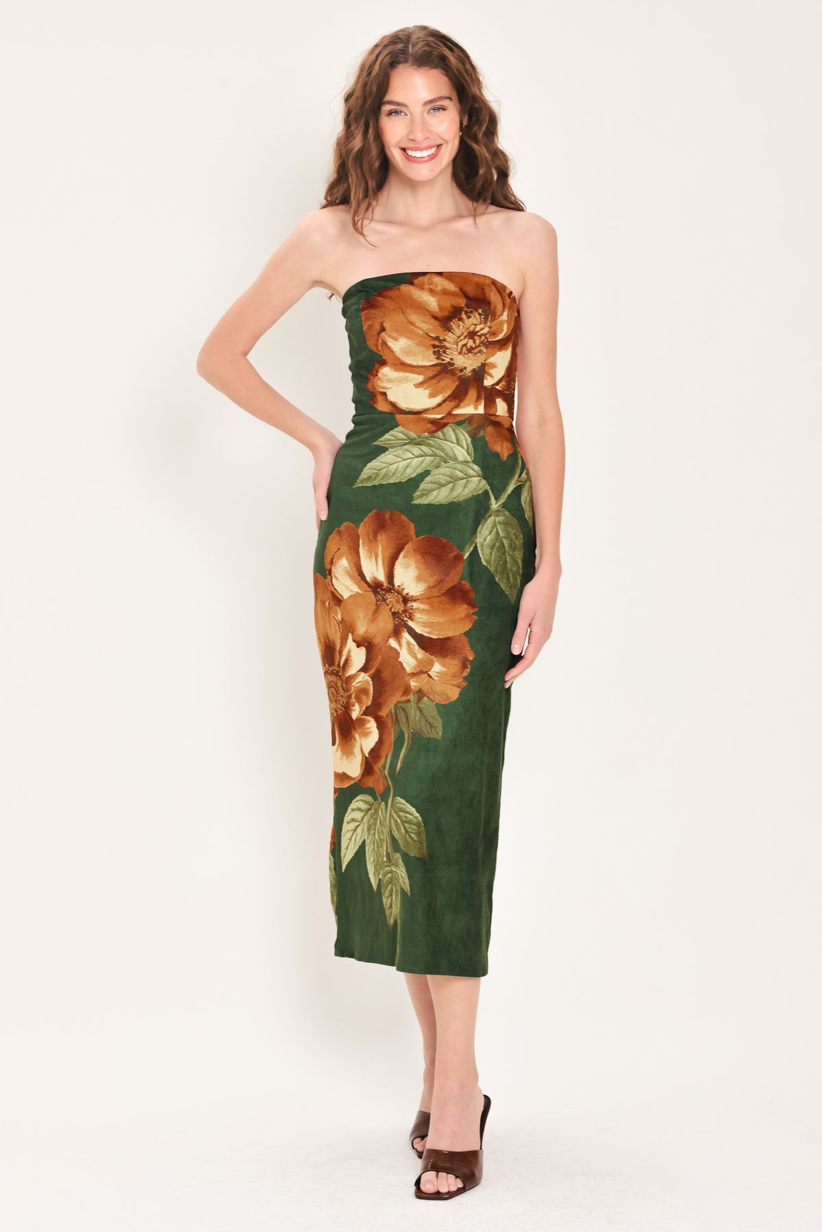 Woman wearing a strapless hunter green suede midi dress with giant rust orange flowers and leaves | Flying Tomato