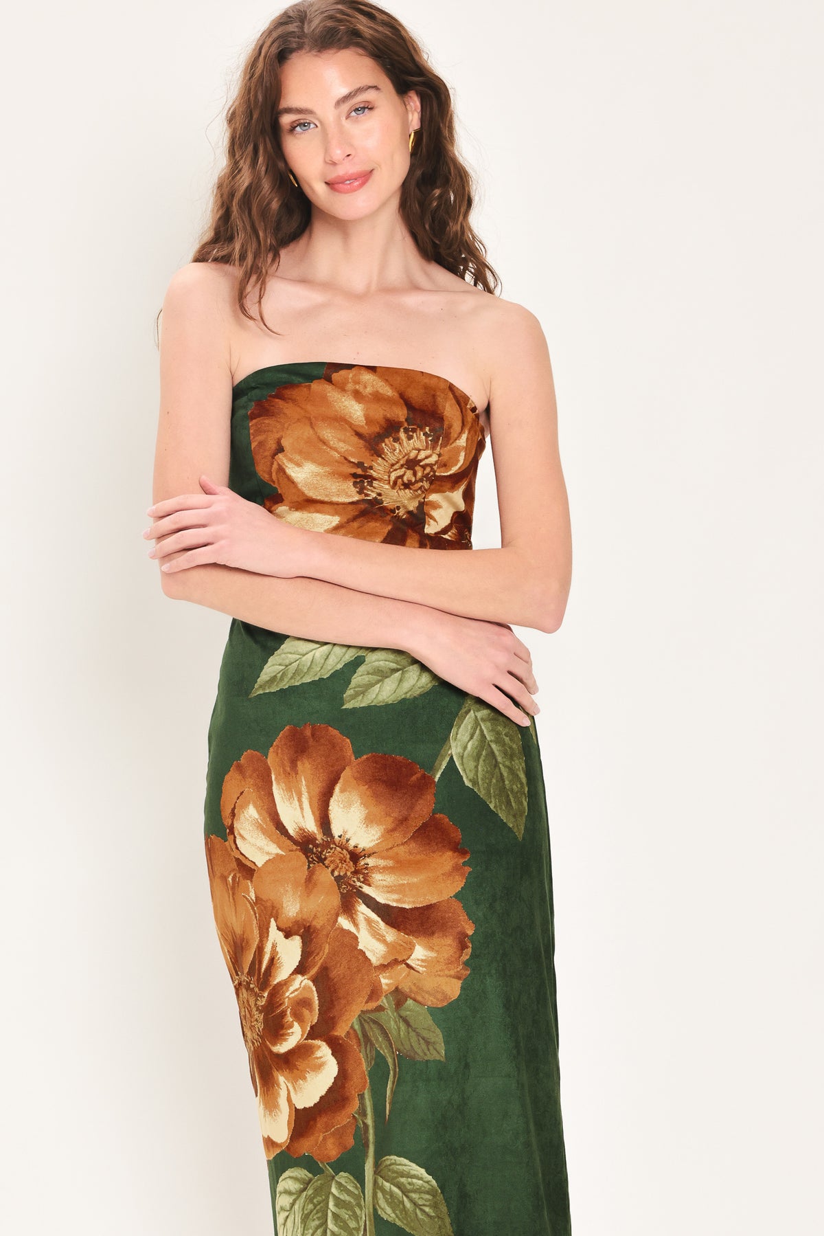 Woman wearing a strapless hunter green suede midi dress with giant rust orange flowers and leaves | Flying Tomato