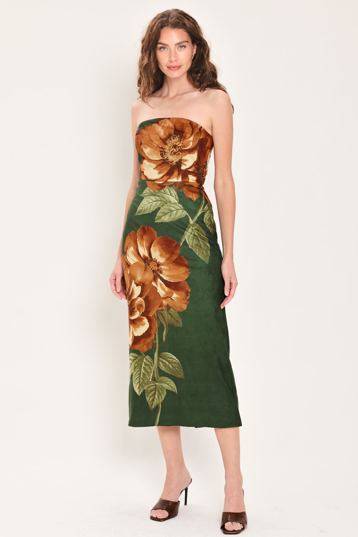 Woman wearing a strapless hunter green suede midi dress with giant rust orange flowers and leaves | Flying Tomato