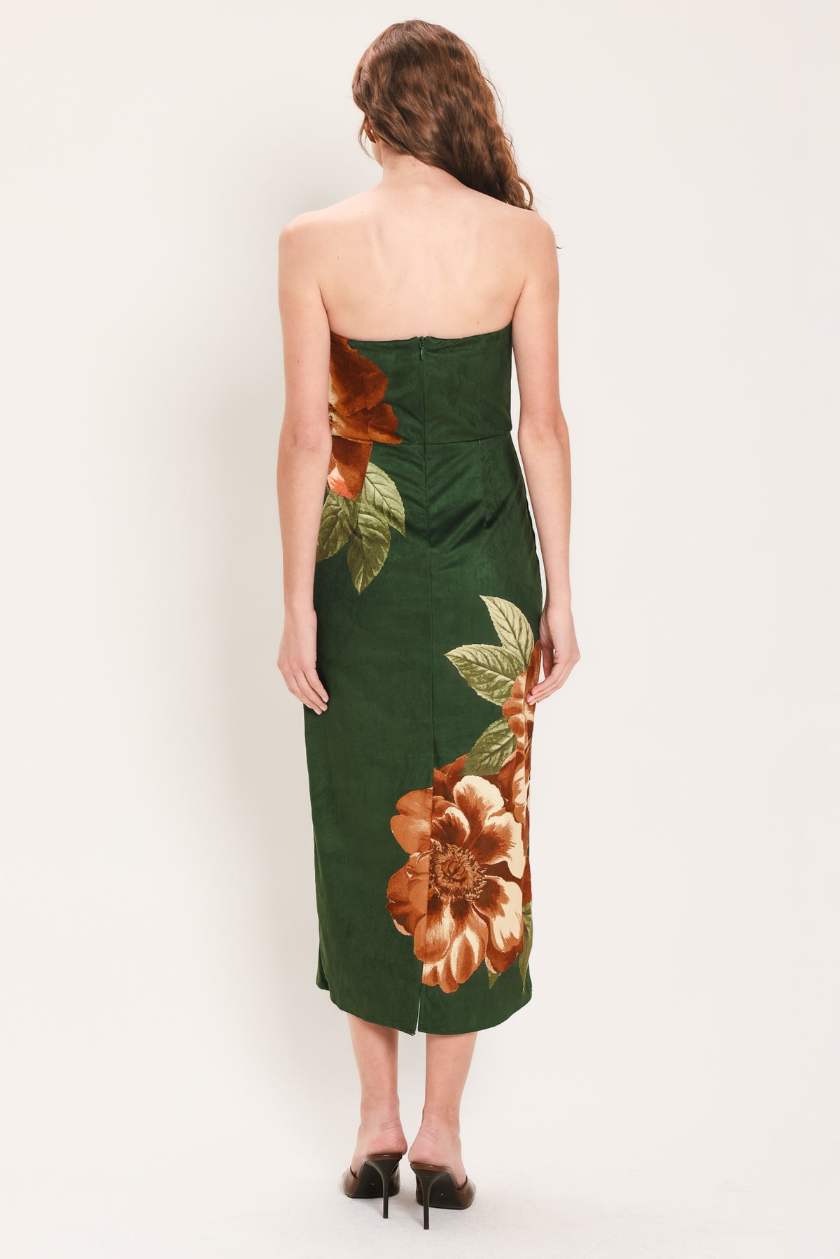 Woman wearing a strapless hunter green suede midi dress with giant rust orange flowers and leaves | Flying Tomato