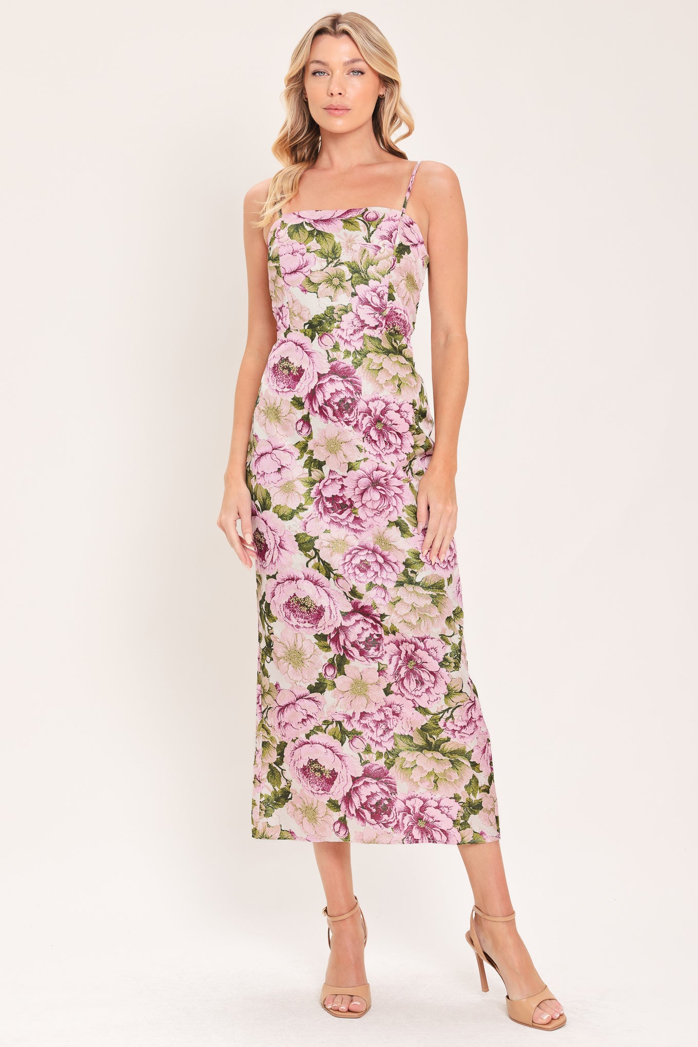 A woman modeling a sleeveless midi dress with thin straps and a ivory and mauve floral print | Flying Tomato