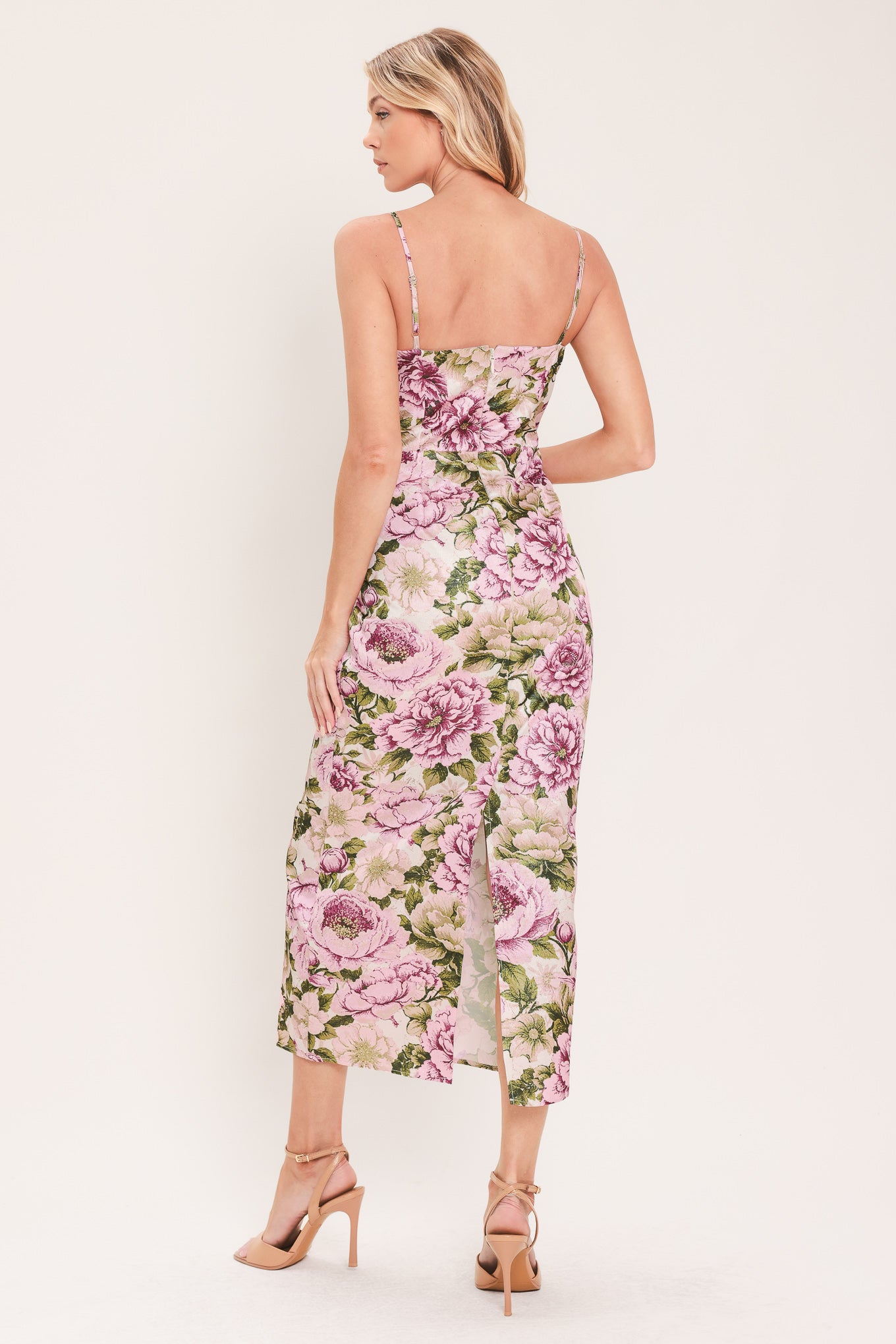 A woman modeling a sleeveless midi dress with thin straps and a ivory and mauve floral print | Flying Tomato