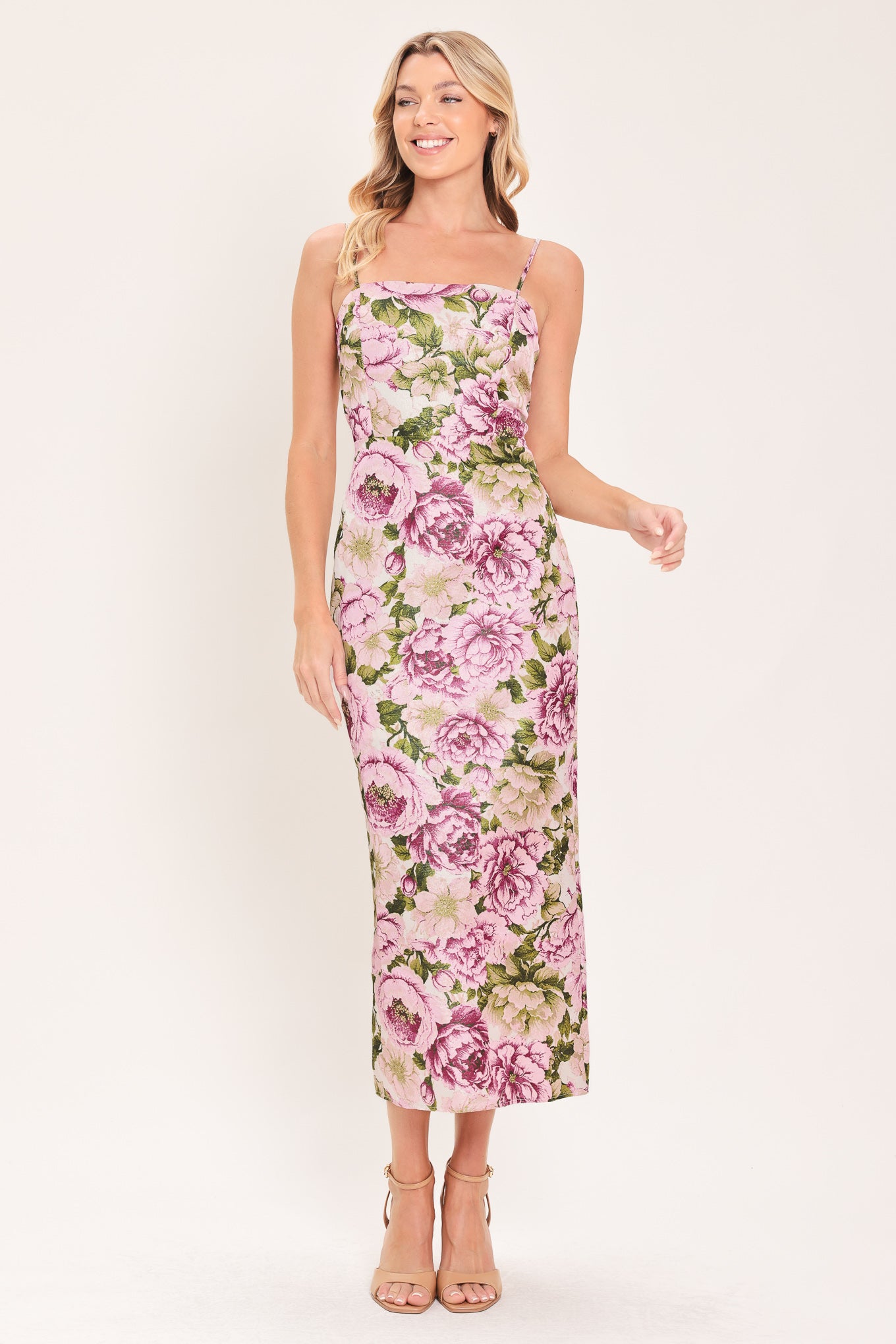 A woman modeling a sleeveless midi dress with thin straps and a ivory and mauve floral print | Flying Tomato