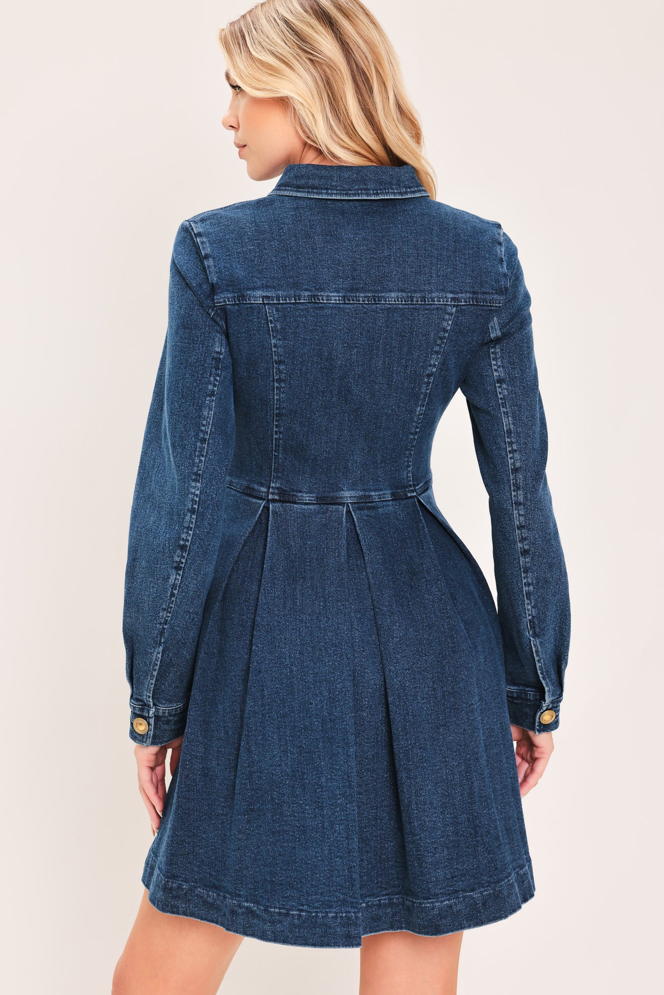 A woman modeling a blue denim long-sleeve shirt dress with gold-tone buttons | Flying Tomato