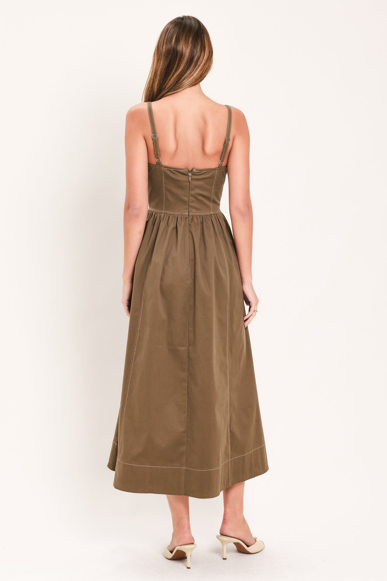 Woman wearing a cool tone brown sleeveless midi dress with bustier stitching details and princess cut waistline | Flying Tomato