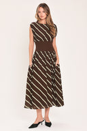 A woman modeling a sleeveless midi dress with a brown and cream diagonal striped pattern, featuring a defined waistband | Flying Tomato