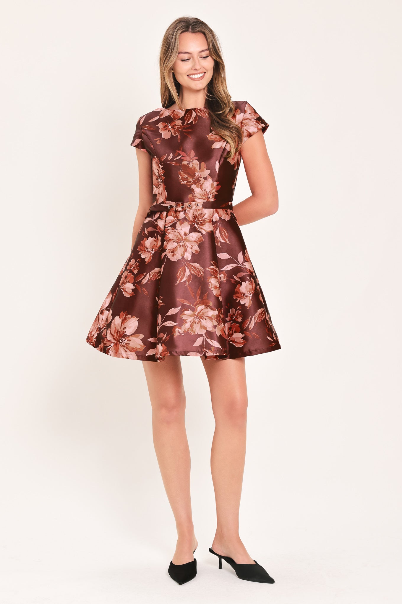 A woman modeling a short-sleeve fit-and-flare dress with a burgundy satin-like base and a pink floral pattern | Flying Tomato
