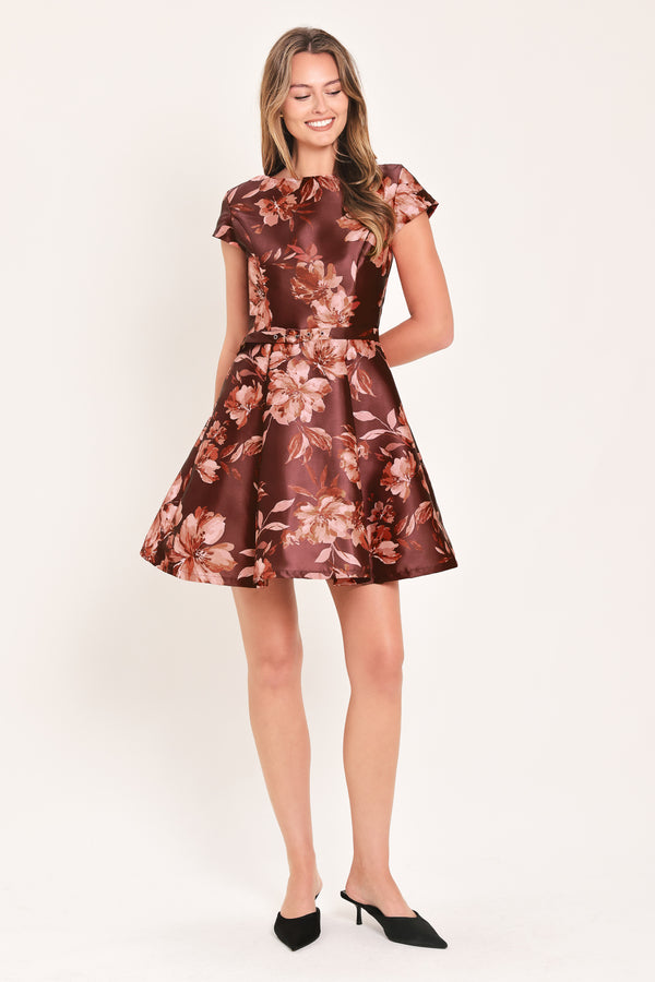 A woman modeling a short-sleeve fit-and-flare dress with a burgundy satin-like base and a pink floral pattern | Flying Tomato