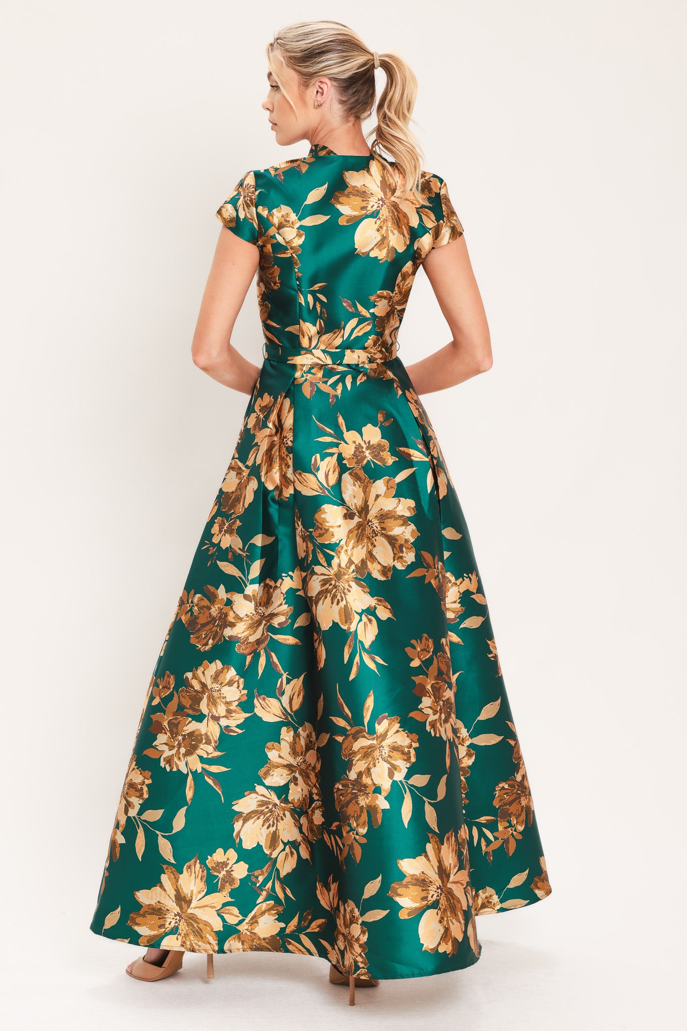 A woman modeling a maxi green satin dress with a gold floral print | Flying Tomato
