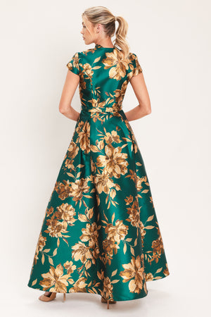 A woman modeling a maxi green satin dress with a gold floral print | Flying Tomato