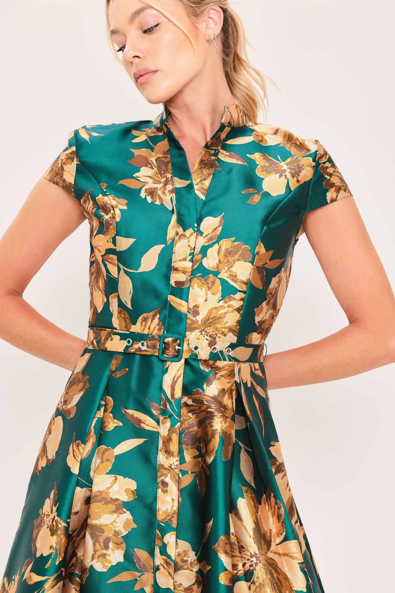 A woman modeling a maxi green satin dress with a gold floral print | Flying Tomato