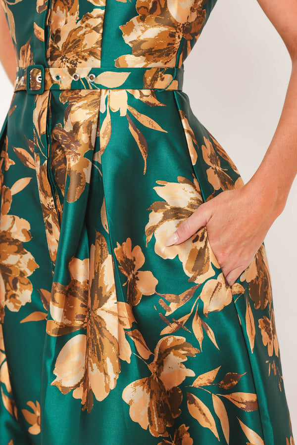 A woman modeling a maxi green satin dress with a gold floral print | Flying Tomato