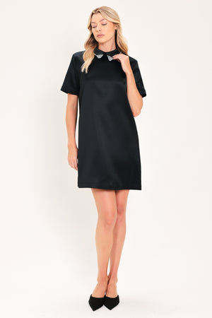 A woman modeling a black short-sleeve satin dress with a decorative silver collar | Flying Tomato