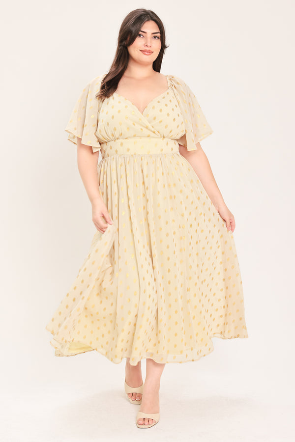 A woman modeling a light yellow midi dress with a small gold dotted pattern, featuring flutter sleeves and a V-neckline | Flying Tomato Curve