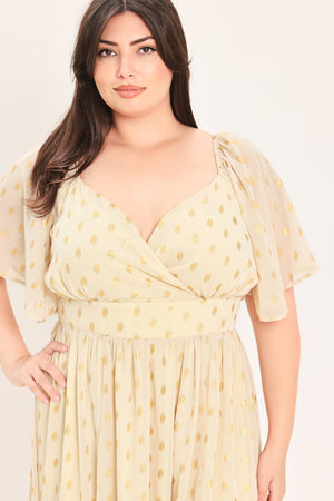A woman modeling a light yellow midi dress with a small gold dotted pattern, featuring flutter sleeves and a V-neckline | Flying Tomato Curve