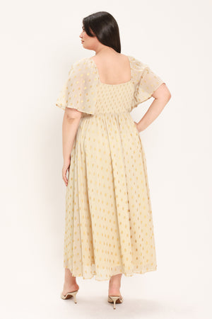 A woman modeling a light yellow midi dress with a small gold dotted pattern, featuring flutter sleeves and a V-neckline | Flying Tomato Curve