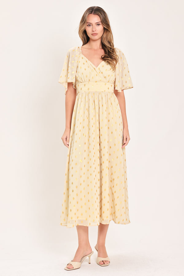 A woman modeling a light yellow midi dress with a small gold dotted pattern, featuring flutter sleeves and a V-neckline | Flying Tomato