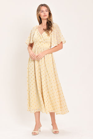 A woman modeling a light yellow midi dress with a small gold dotted pattern, featuring flutter sleeves and a V-neckline | Flying Tomato