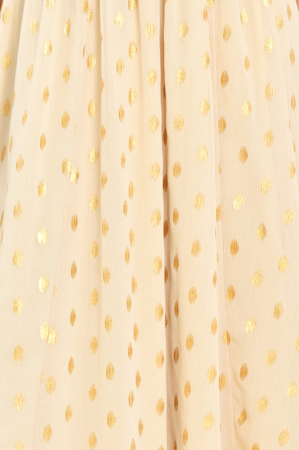 A woman modeling a light yellow midi dress with a small gold dotted pattern, featuring flutter sleeves and a V-neckline | Flying Tomato