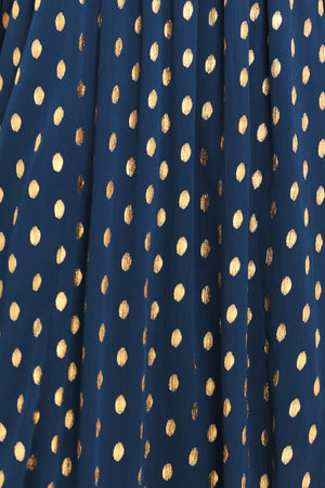 A woman modeling a light yellow midi dress with a small gold dotted pattern, featuring flutter sleeves and a V-neckline | Flying Tomato