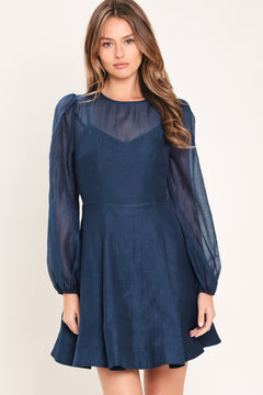 Woman wearing a blue mini dress with sheer long sleeves featuring round neckline, long sleeve, circle skirt and back zipper closure | Flying Tomato