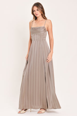 A woman modeling a floor-length taupe pleated maxi dress with spaghetti straps and a gathered sweetheart neckline | Flying Tomato