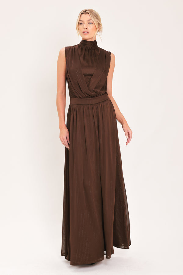 A woman modeling a sleeveless, high-neck, maxi brown dress | Flying Tomato