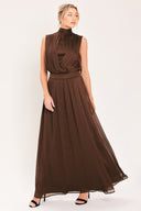 A woman modeling a sleeveless, high-neck, maxi brown dress | Flying Tomato