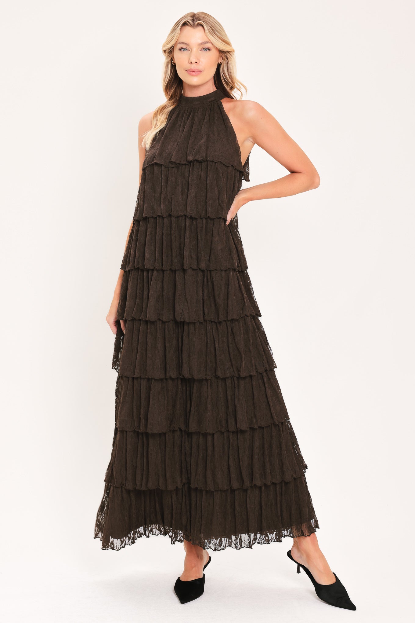 A woman modeling a sleeveless, high-neck, tiered maxi dress in a dark brown color | Flying Tomato