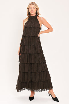 A woman modeling a sleeveless, high-neck, tiered maxi dress in a dark brown color | Flying Tomato