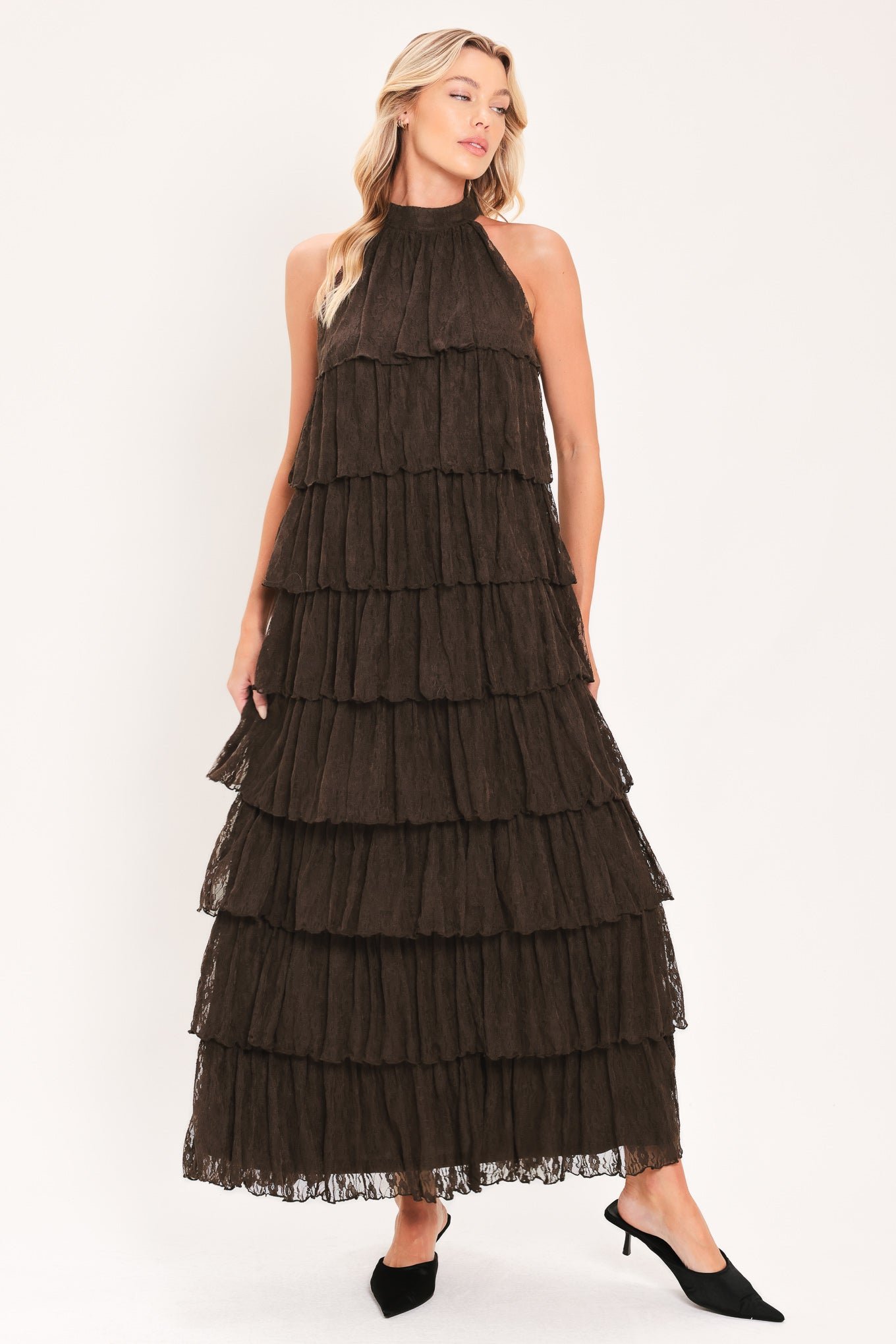 A woman modeling a sleeveless, high-neck, tiered maxi dress in a dark brown color | Flying Tomato