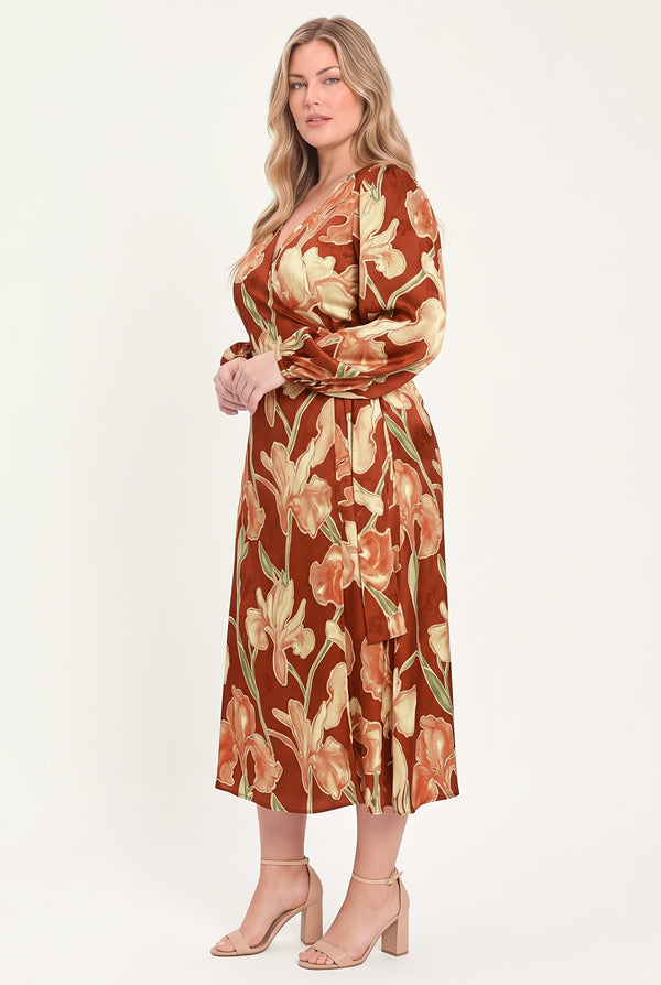 A woman modeling a long-sleeve midi wrap dress with a brown, beige, and green floral pattern | Flying Tomato
