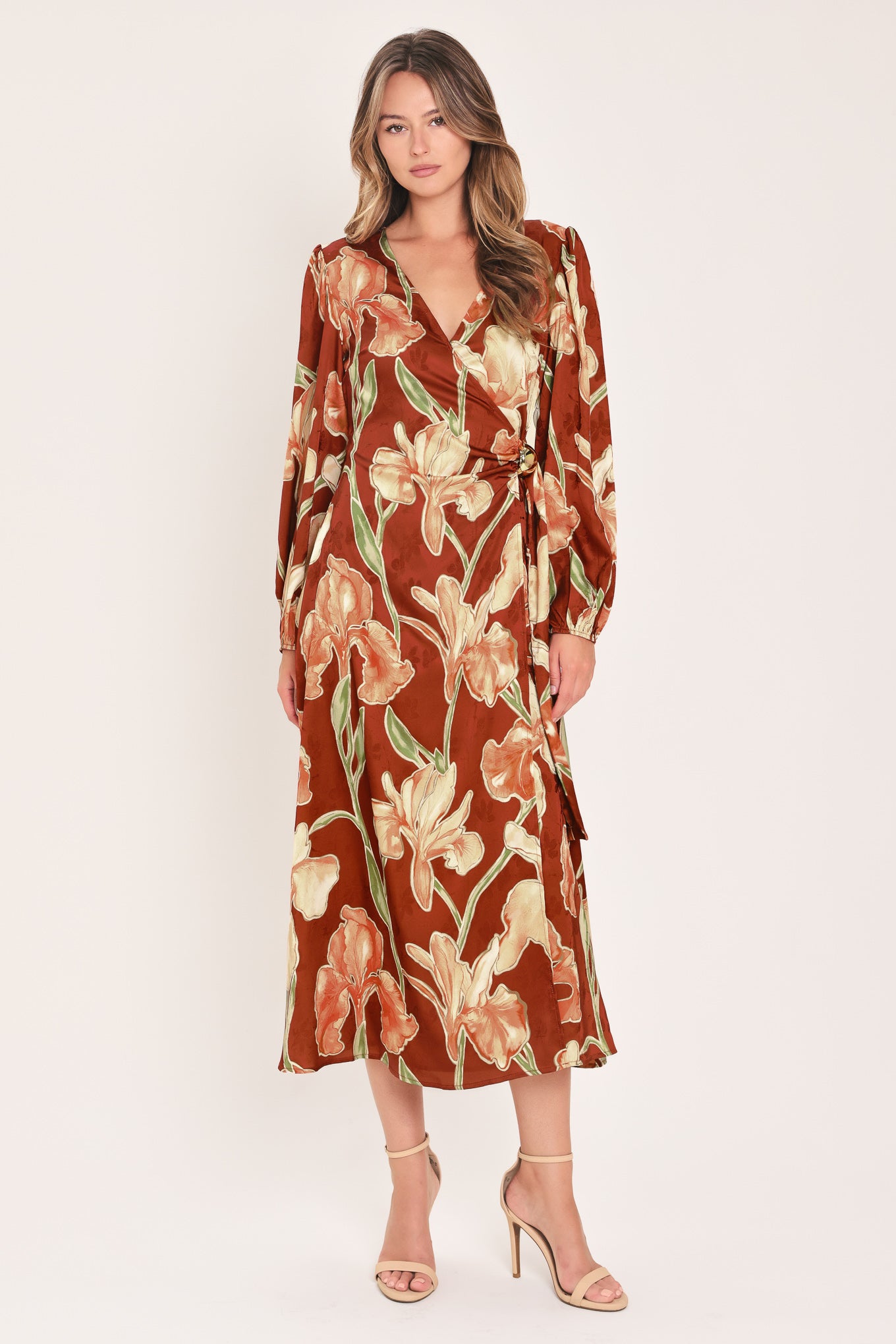 A woman modeling a long-sleeve midi wrap dress with a brown, beige, and green floral pattern | Flying Tomato