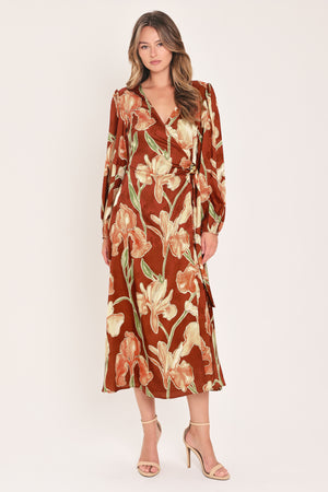 A woman modeling a long-sleeve midi wrap dress with a brown, beige, and green floral pattern | Flying Tomato