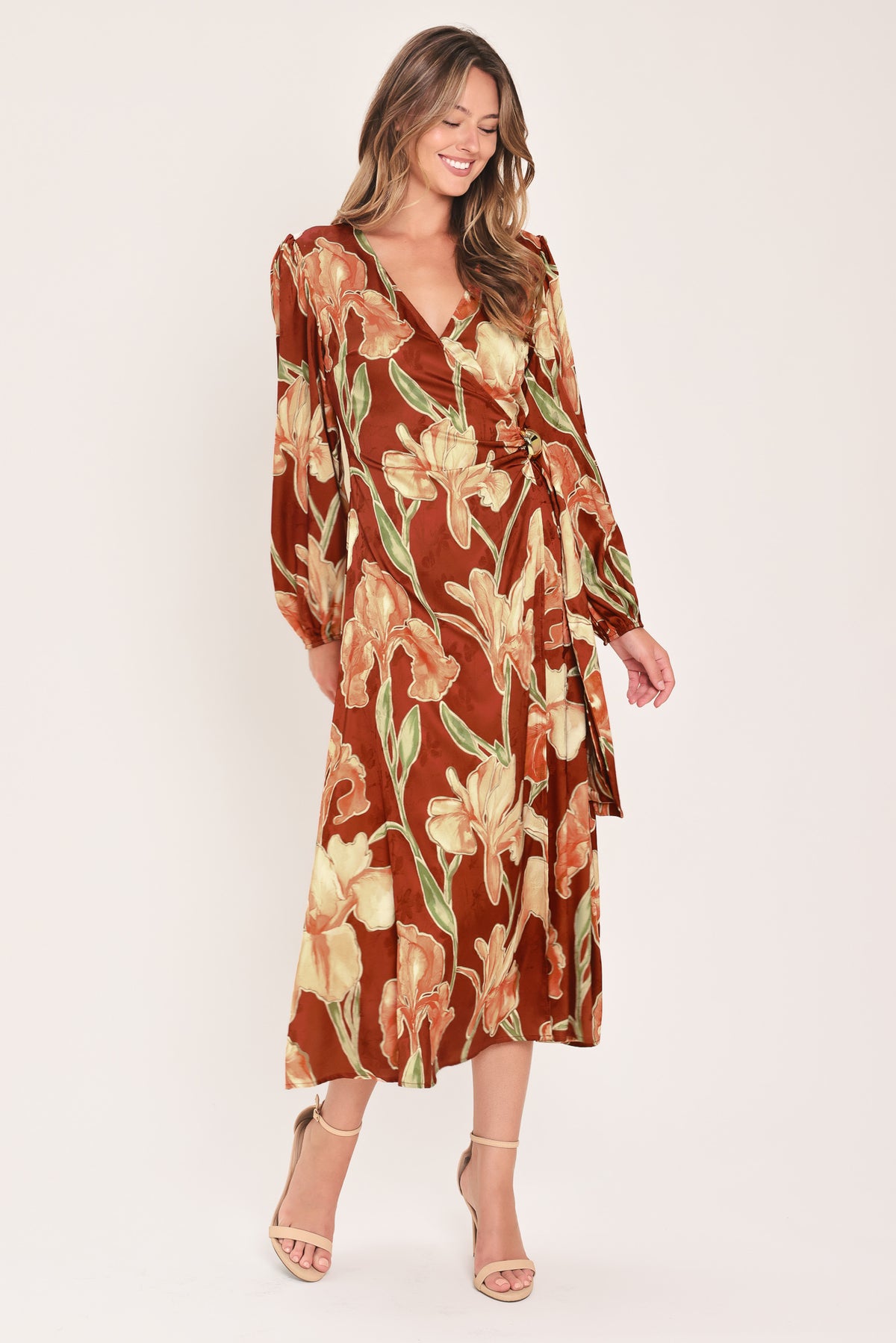 A woman modeling a long-sleeve midi wrap dress with a brown, beige, and green floral pattern | Flying Tomato