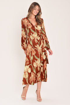 A woman modeling a long-sleeve midi wrap dress with a brown, beige, and green floral pattern | Flying Tomato