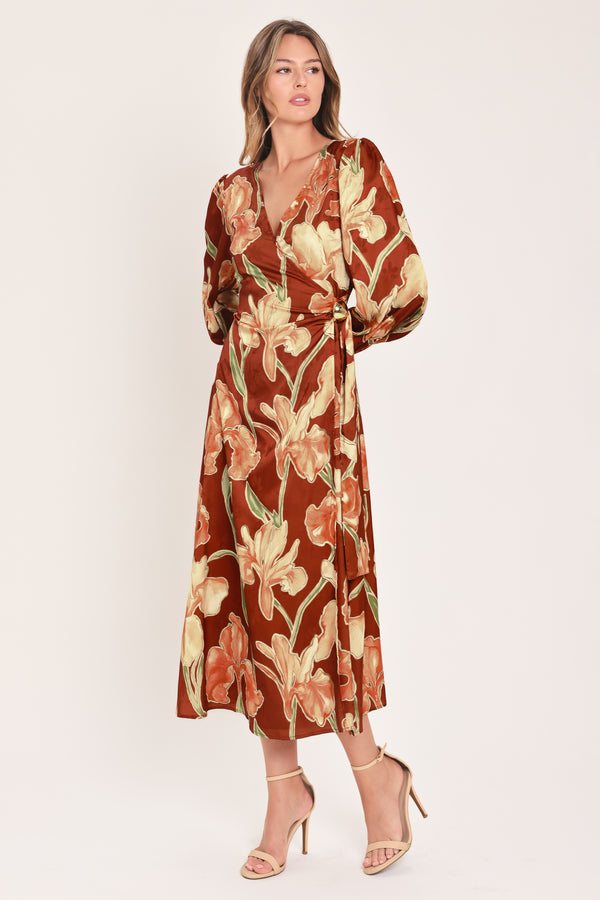 A woman modeling a long-sleeve midi wrap dress with a brown, beige, and green floral pattern | Flying Tomato