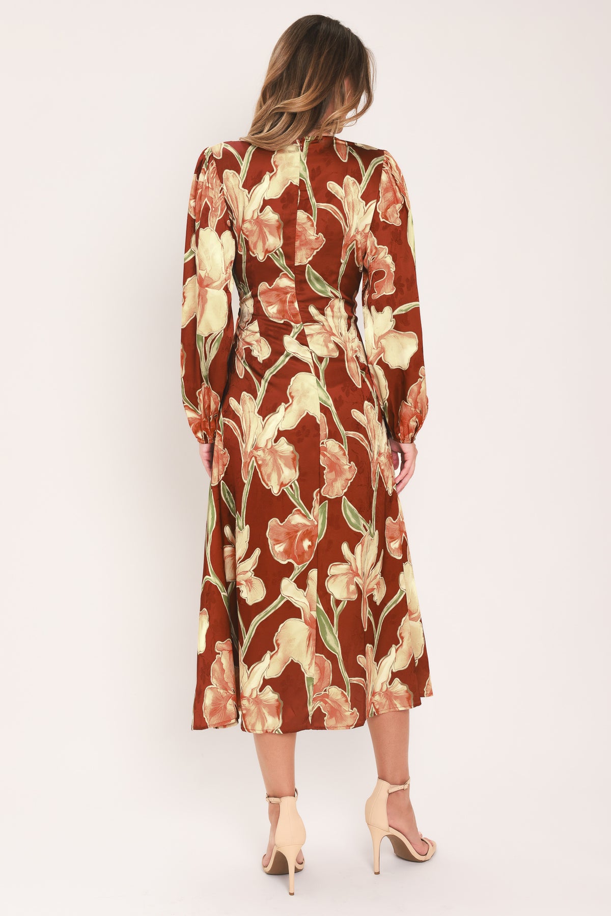 A woman modeling a long-sleeve midi wrap dress with a brown, beige, and green floral pattern | Flying Tomato